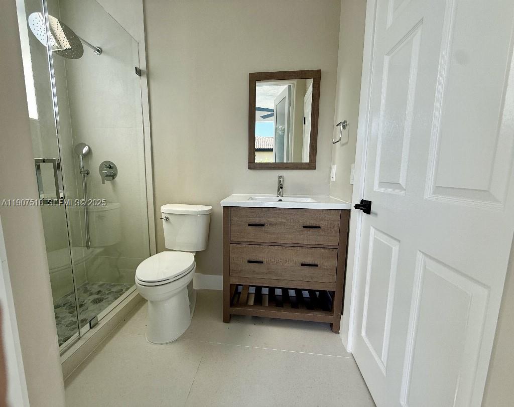 12427 Southwest 121st Avenue Miami, FL 33186 - Photo 11 of 33 a bathroom with a toilet a sink a mirror and shower