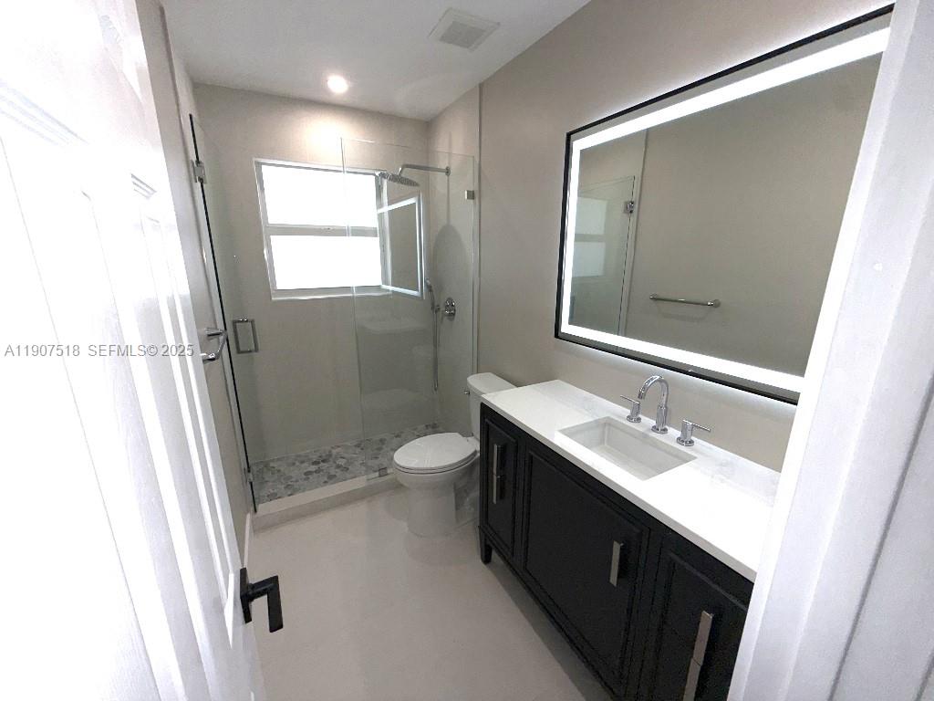 12427 Southwest 121st Avenue Miami, FL 33186 - Photo 15 of 33 a bathroom with a double vanity sink toilet and shower