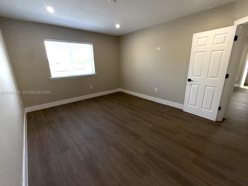 12427 Southwest 121st Avenue Miami, FL 33186 - Photo 20 of 33 an empty room with wooden floor and windows