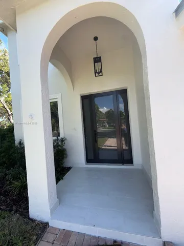 a view of a hallway to a livingroom with furniture and window