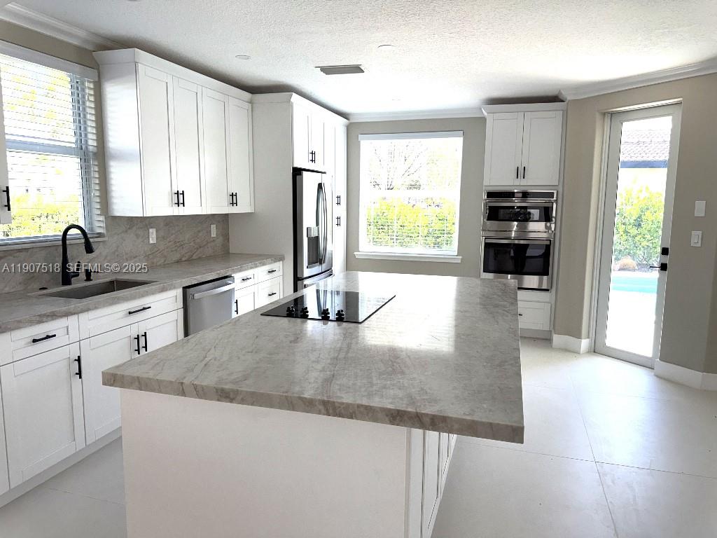 12427 Southwest 121st Avenue Miami, FL 33186 - Photo 9 of 33 a kitchen with granite countertop a refrigerator and a sink