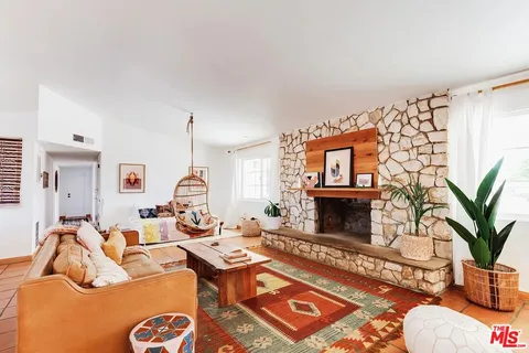 a living room with furniture fireplace and wooden floor