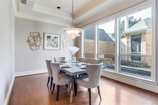 a dining room with furniture a chandelier and wooden floor