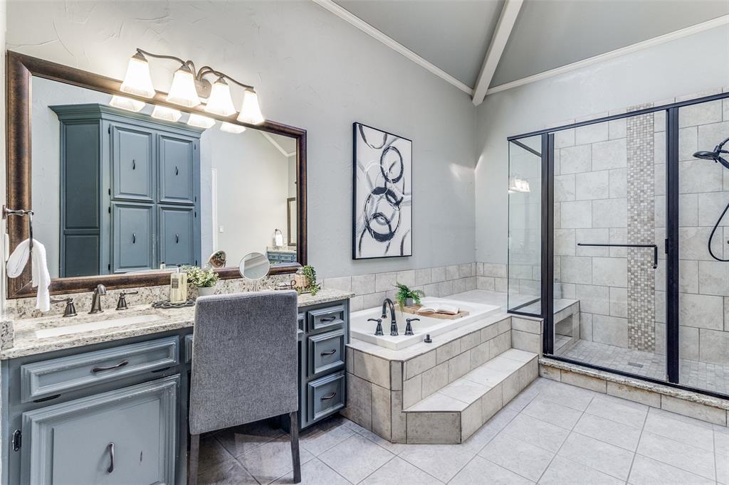 7155 Helsem Bend Circle Dallas, TX 75230 - Photo 20 of 26 a bathroom with a granite countertop sink a mirror a bathtub and shower