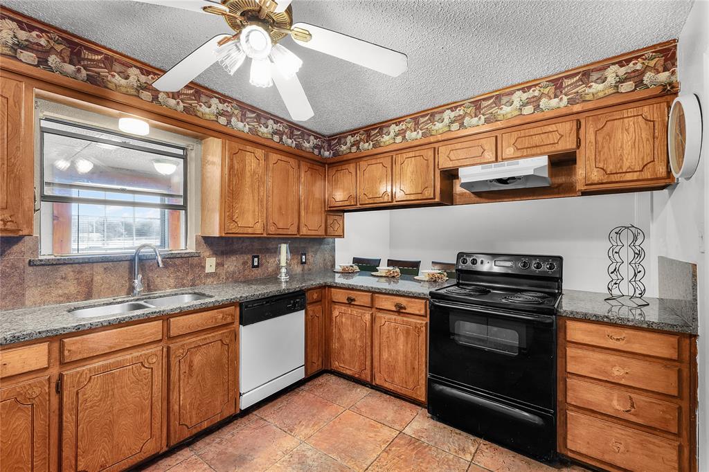 748 Rocky Ridge Lane Weatherford, TX 76085 - Photo 26 of 38 a kitchen with stainless steel appliances granite countertop a stove and cabinets