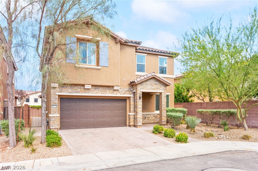 11048 Prairie Grove Road Las Vegas, NV 89179 - Photo 4 of 75 A welcoming facade with stone accents and a paver driveway beckons entry to this comfortable residence.