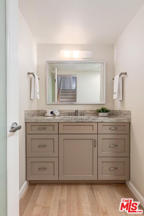 13336 Maxella Avenue, Unit 5 Marina del Rey, CA 90292 - Photo 11 of 26 a bathroom with a granite countertop sink and a mirror