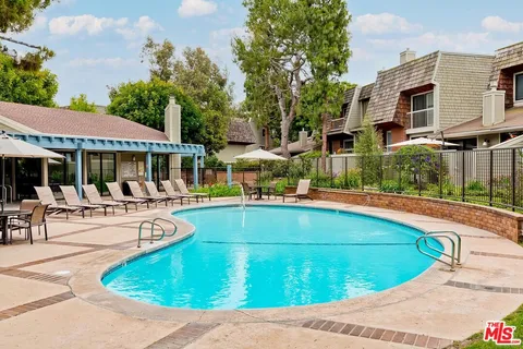a view of a house with swimming pool and sitting area
