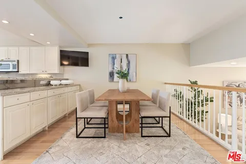 a kitchen with white cabinets and window