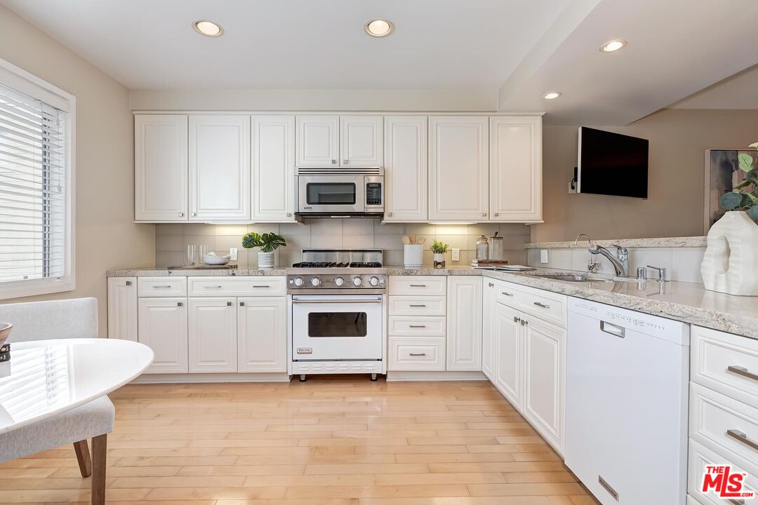 13336 Maxella Avenue, Unit 5 Marina del Rey, CA 90292 - Photo 8 of 26 a kitchen with granite countertop white cabinets and white appliances