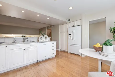 a spacious bathroom with stainless steel appliances a sink and a refrigerator