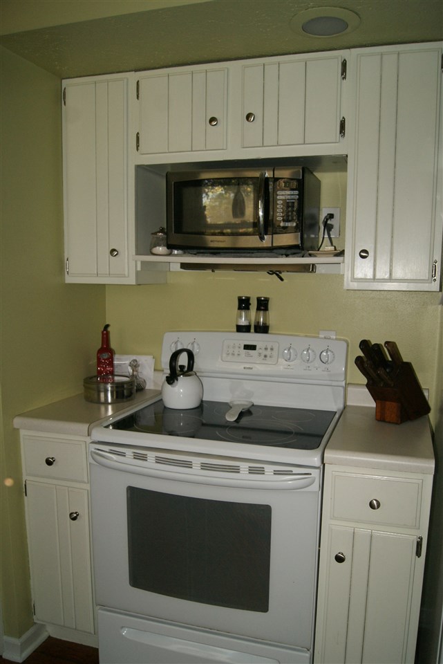 14476 Russellville Road Capron, IL 61012 - Photo 12 of 25 a kitchen with stainless steel appliances granite countertop white cabinets and a stove top oven