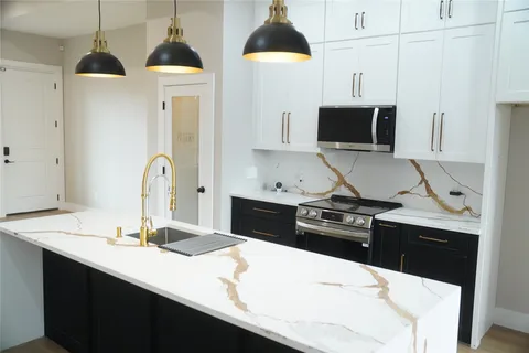 a kitchen with a sink a stove and microwave