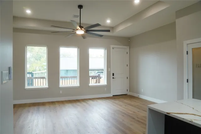a large kitchen with stainless steel appliances kitchen island a large counter top and wooden floors