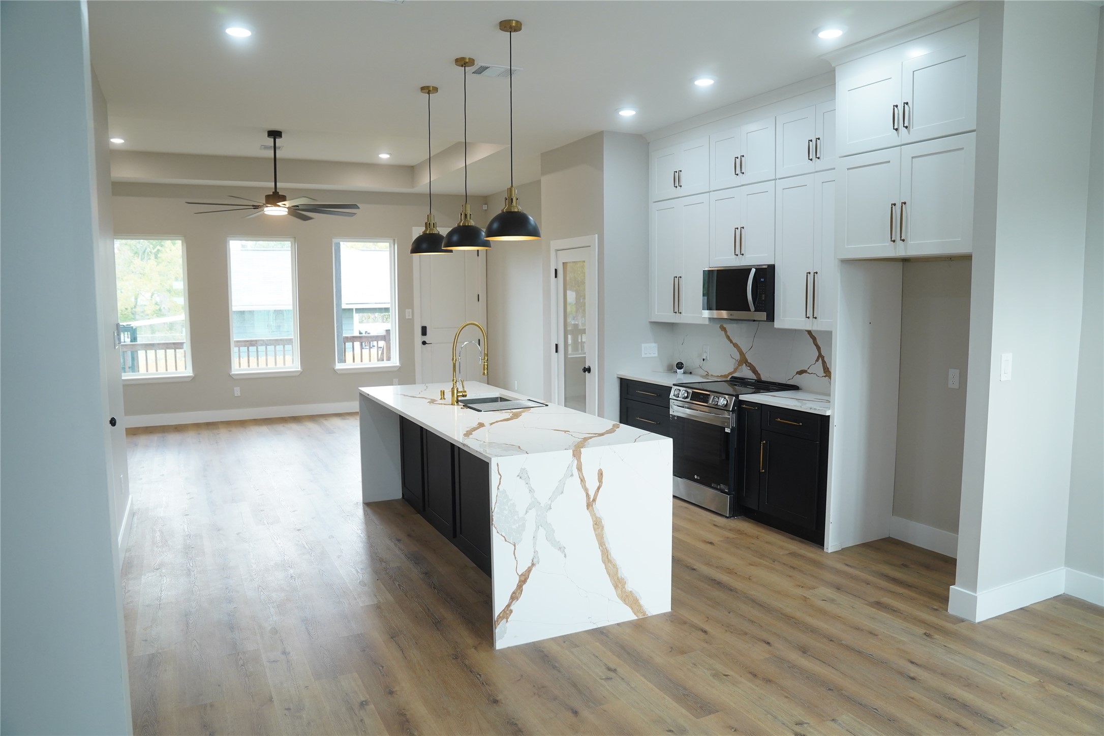 5947 Collingsworth Street Houston, TX 77026 - Photo 12 of 39 a large kitchen with stainless steel appliances kitchen island a large counter top and wooden floors
