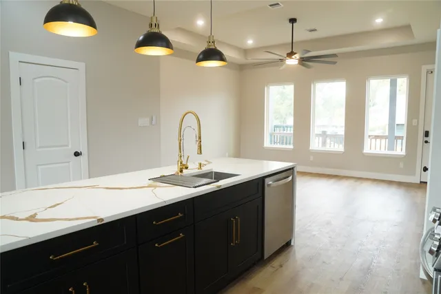 a living room with stainless steel appliances kitchen island granite countertop furniture a rug a fireplace and a window