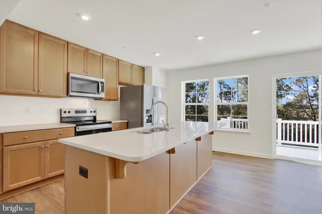 a kitchen with stainless steel appliances a refrigerator stove microwave and sink