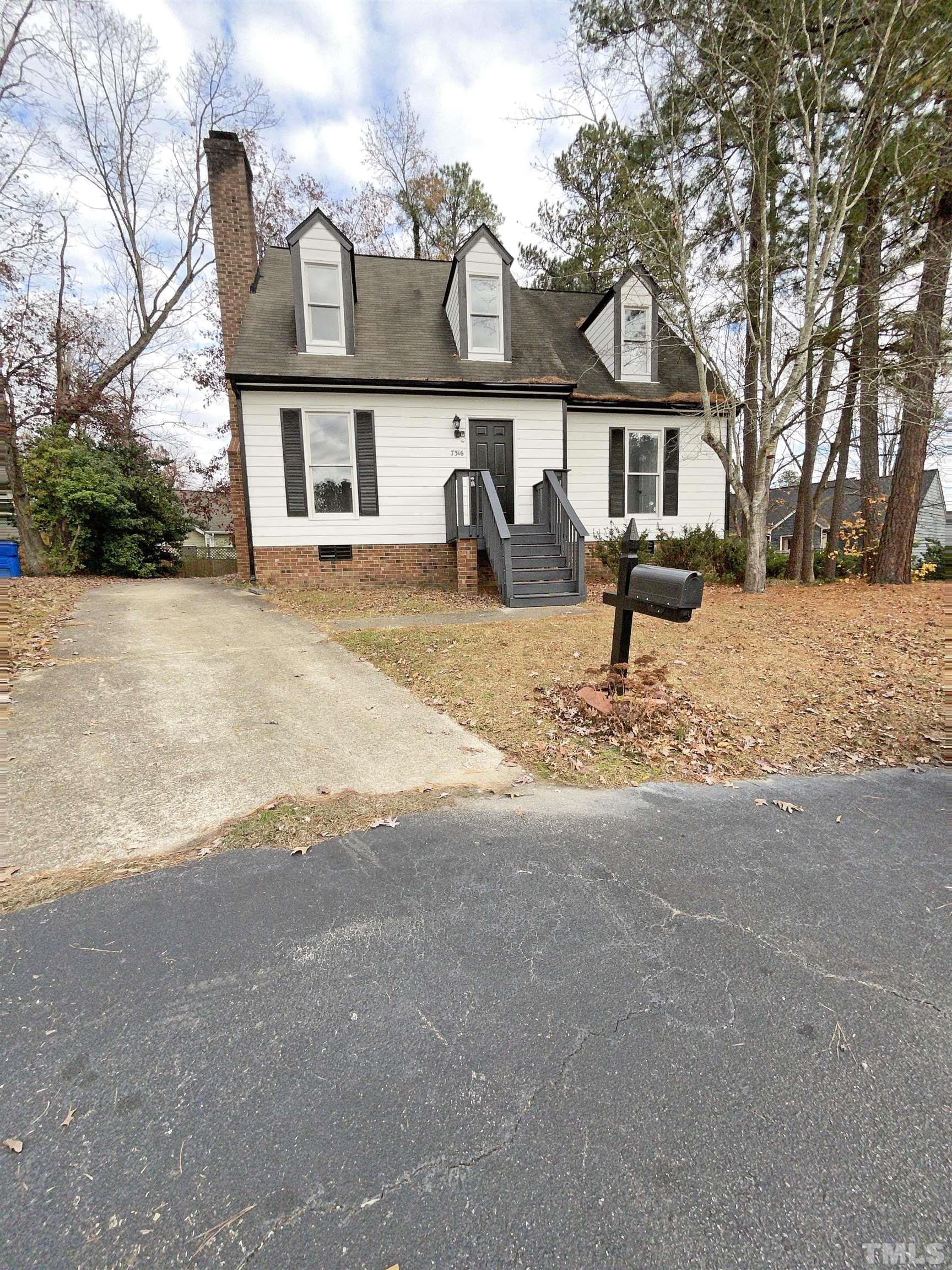a front view of a house with a yard and trees