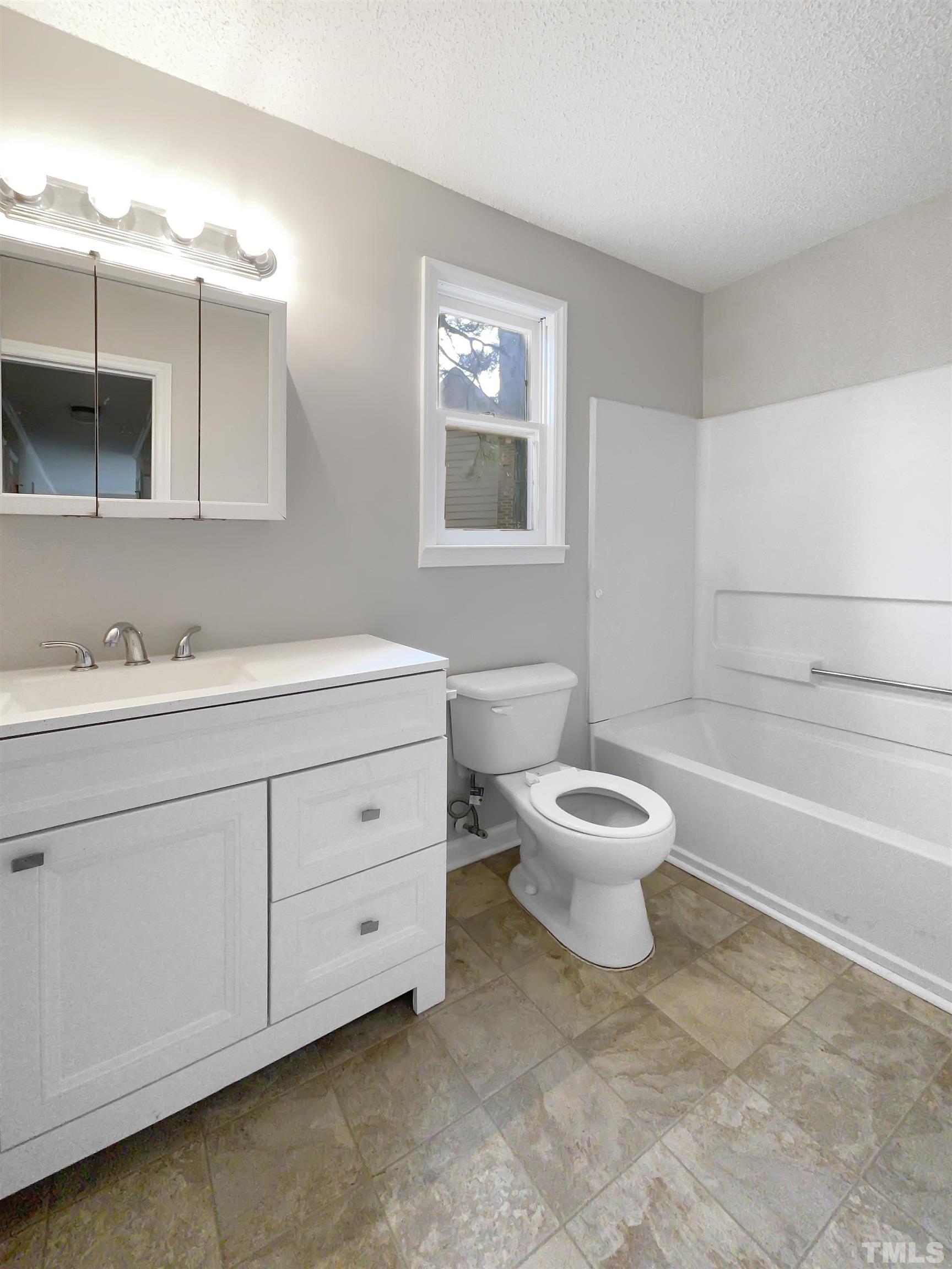 7316 Ewing Place Raleigh, NC 27616 - Photo 16 of 19 a bathroom with a granite countertop toilet a sink and a mirror
