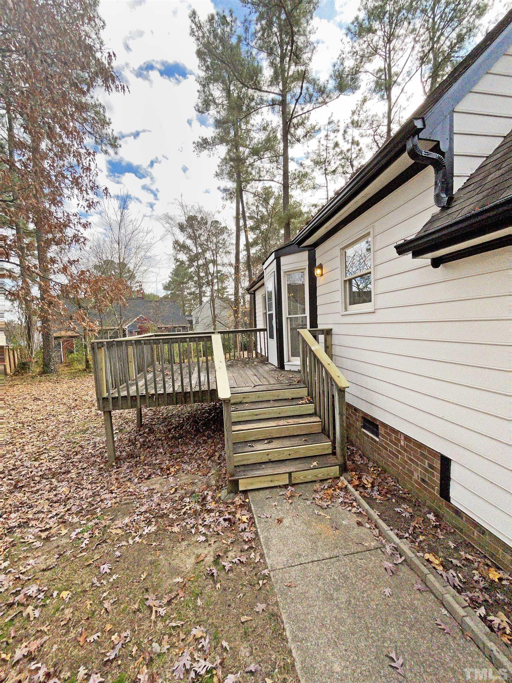 7316 Ewing Place Raleigh, NC 27616 - Photo 17 of 19 a view of a house with a wooden bench next to a road