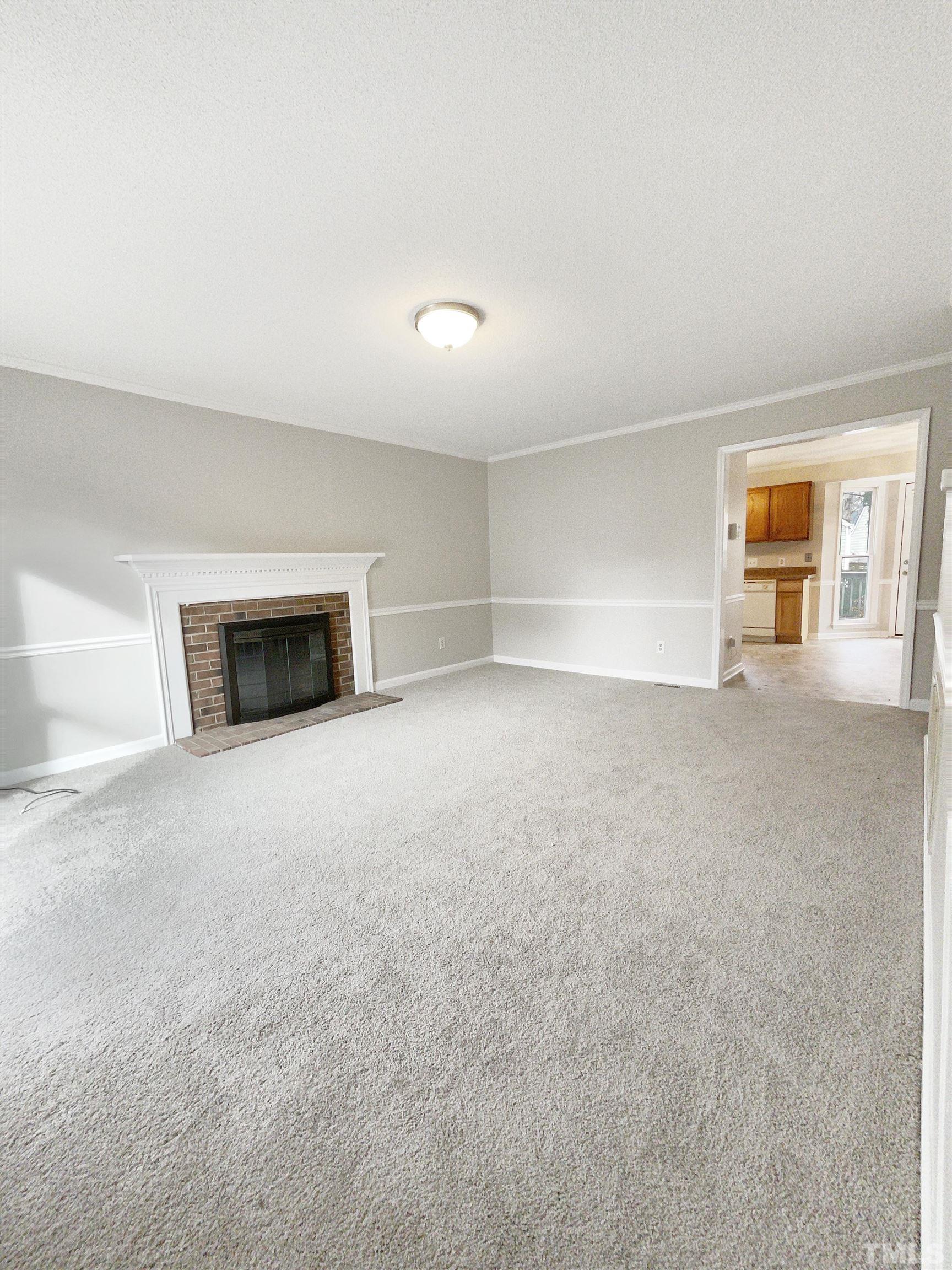 7316 Ewing Place Raleigh, NC 27616 - Photo 3 of 19 a view of an empty room with a fireplace and a window