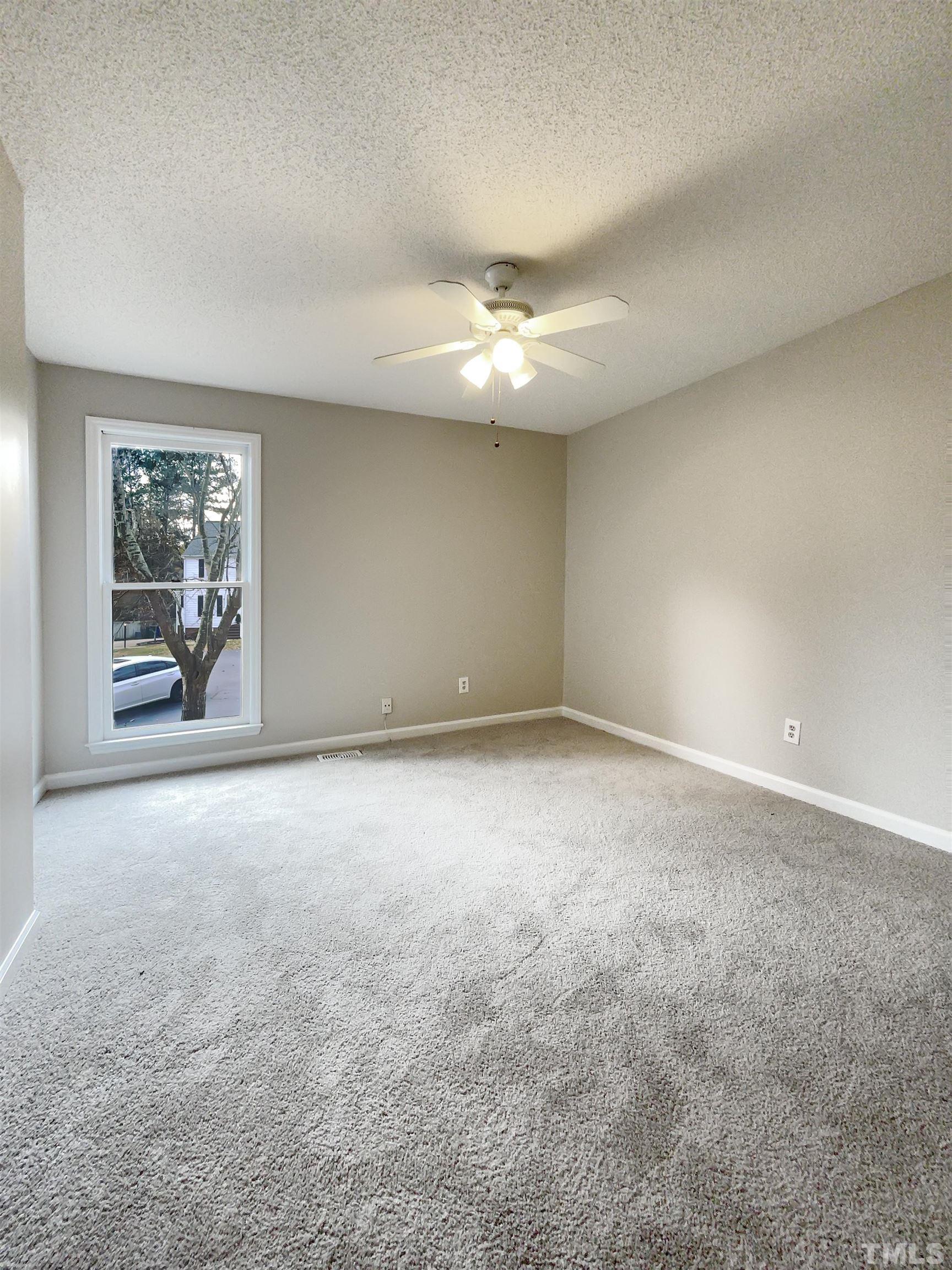 7316 Ewing Place Raleigh, NC 27616 - Photo 6 of 19 an empty room with windows and ceiling fan