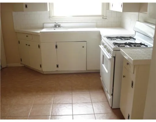 a kitchen with granite countertop a sink and a stove