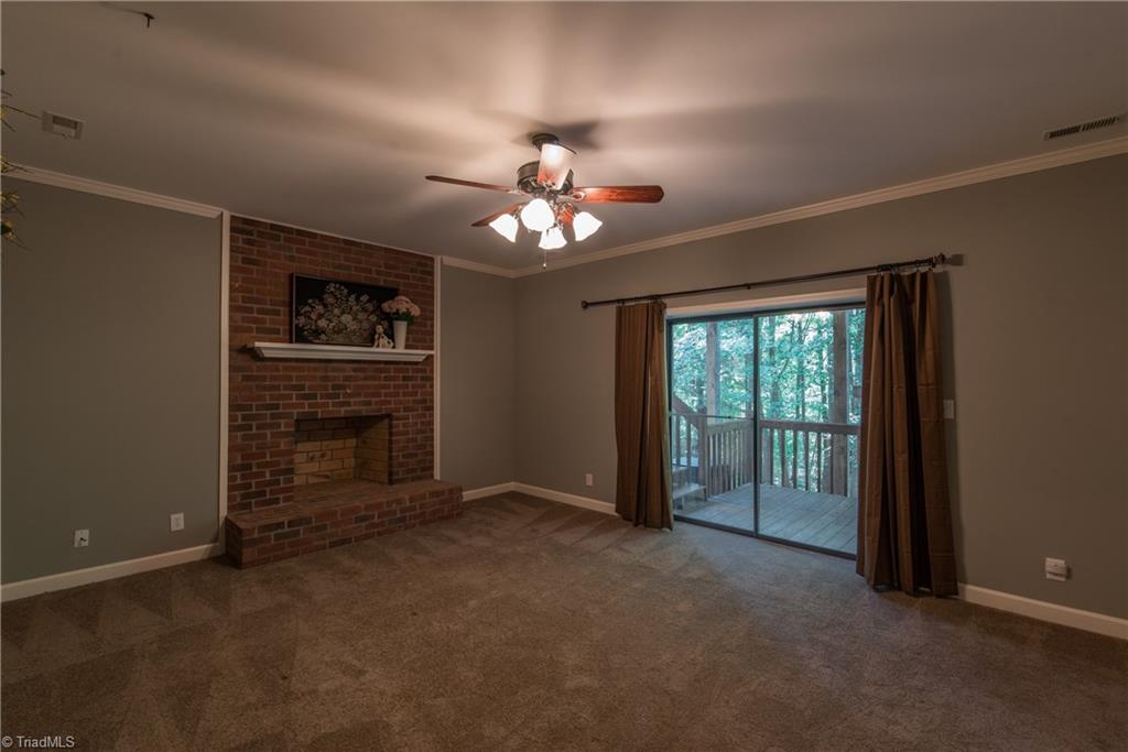 1511 Carters Grove Road Clemmons, NC 27012 - Photo 27 of 30 Basement bonus room with fireplace, with entrance to the carport area and steps to upstairs deck.