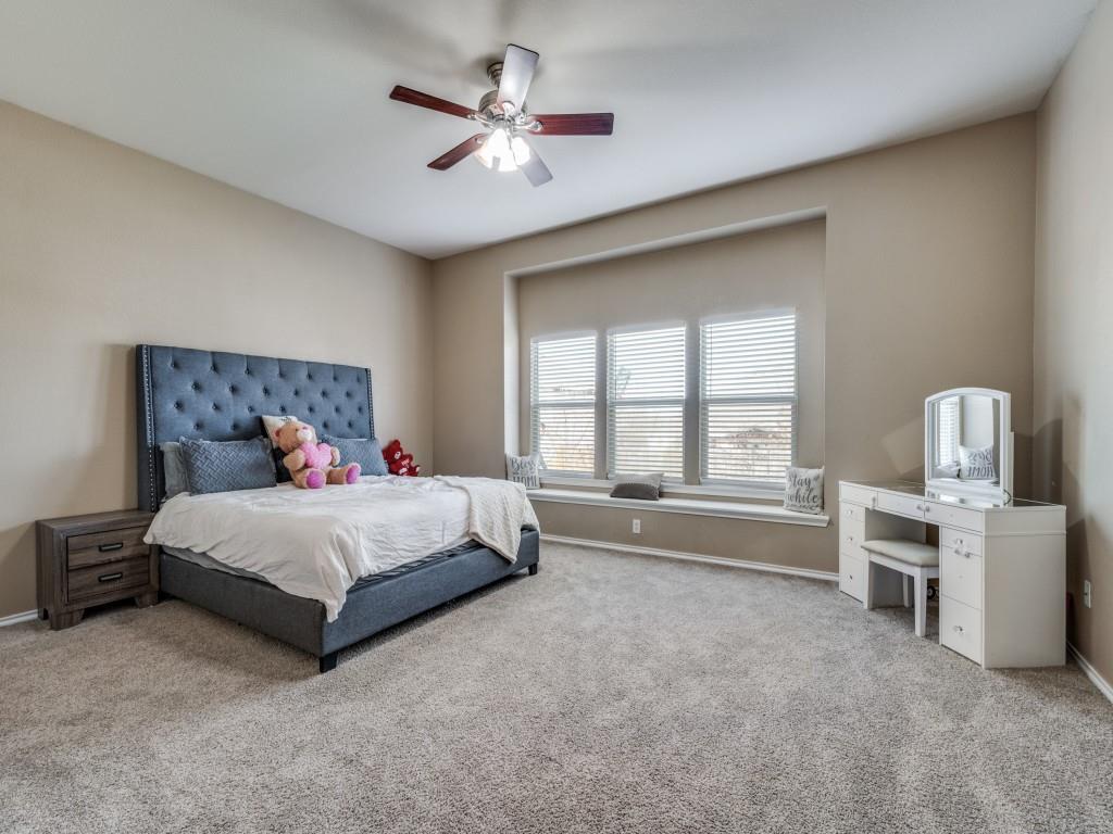 305 Sheridan Road Oak Point, TX 75068 - Photo 13 of 25 a spacious bedroom with a bed and a chandelier