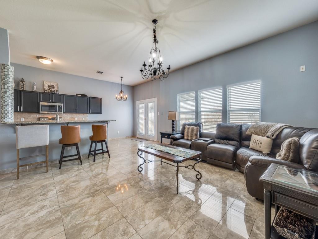305 Sheridan Road Oak Point, TX 75068 - Photo 7 of 25 a living room with furniture a chandelier and a dining table