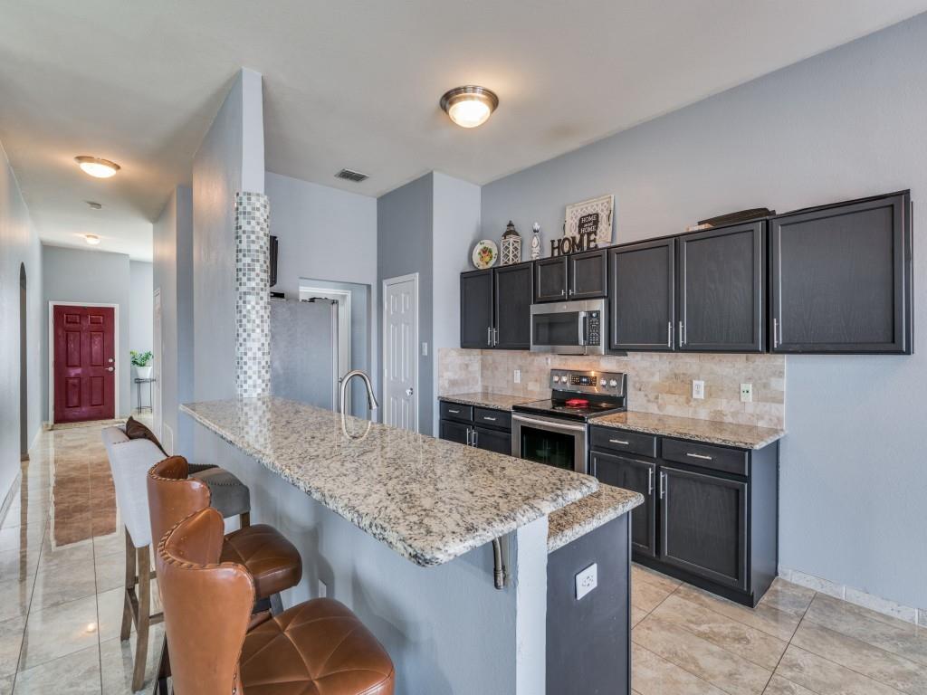 305 Sheridan Road Oak Point, TX 75068 - Photo 9 of 25 a kitchen with granite countertop a stove and a refrigerator