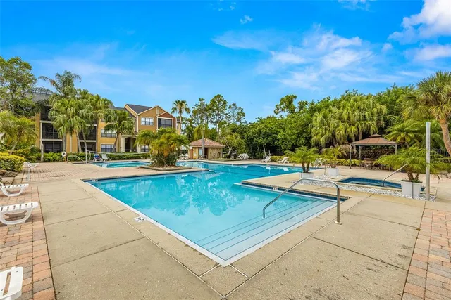 a view of a swimming pool with a patio and a yard