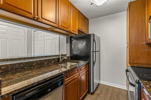 a kitchen with granite countertop stainless steel appliances and wooden cabinets
