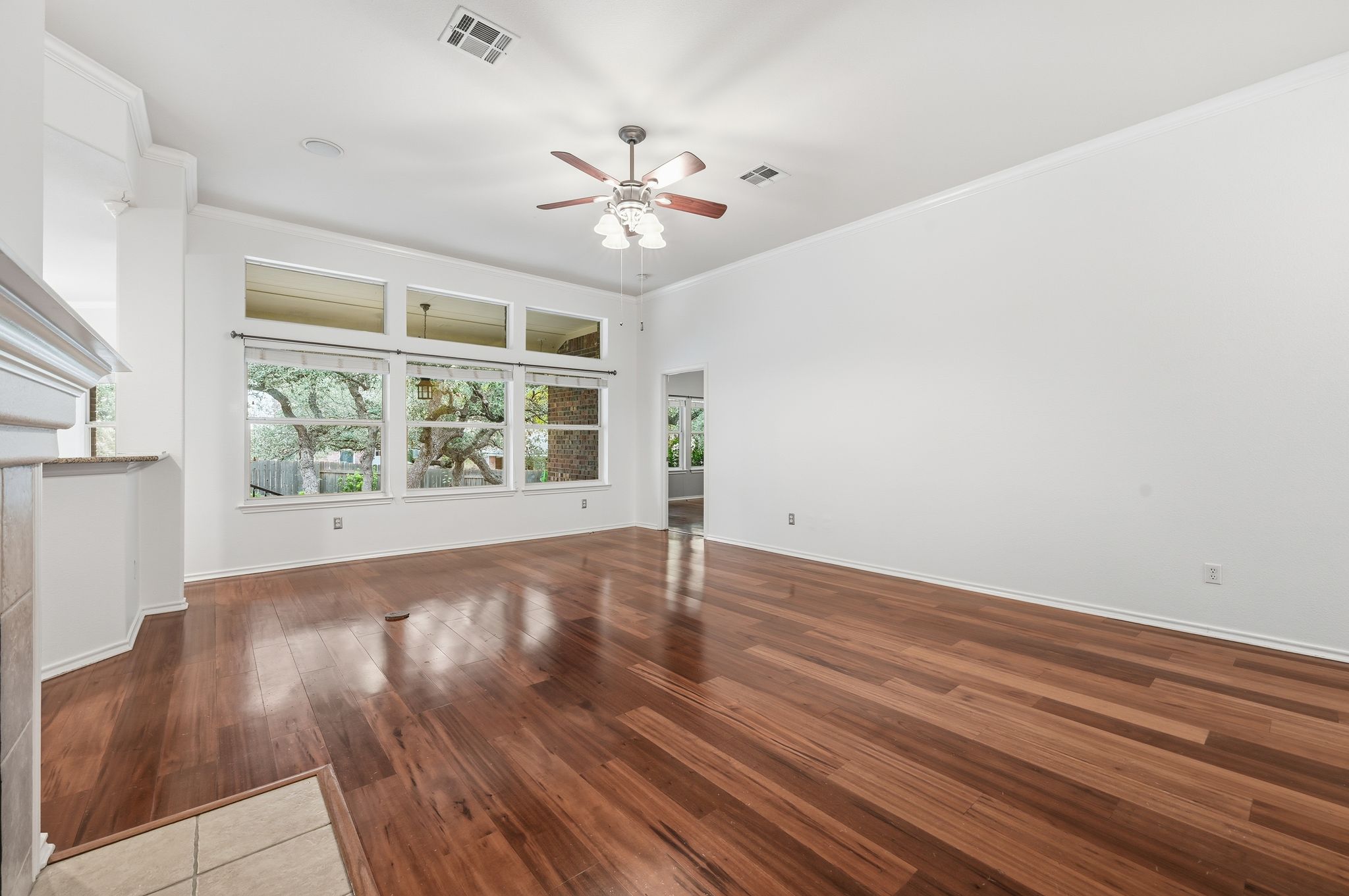 202 Muscovy Lane Cedar Park, TX 78613 - Photo 4 of 34 an empty room with wooden floor chandelier fan and windows