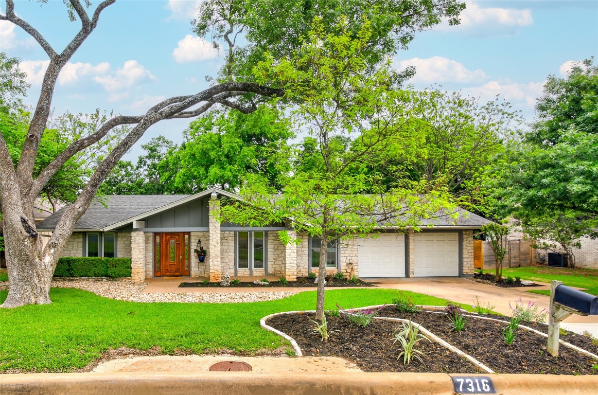 a front view of a house with a yard and trees