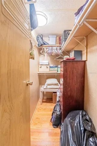a view of a bedroom with a bed and wooden floor