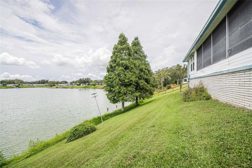 2055 South Floral Avenue, Unit 306 Bartow, FL 33830 - Photo 32 of 42 a view of a lake with a big yard and large trees