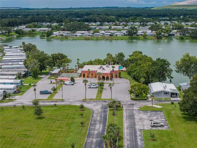 an aerial view of residential houses with outdoor space and lake view