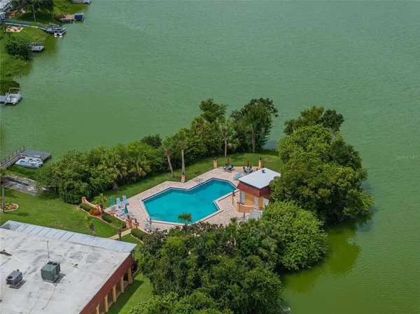 an aerial view of a house with a garden and lake view