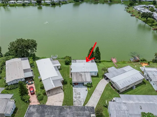 an aerial view of a house with swimming pool and lake view