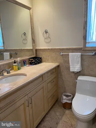 a bathroom with a sink a toilet and mirror