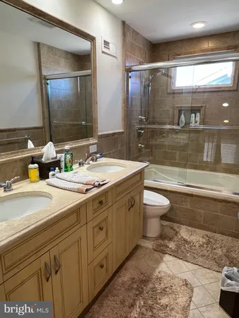 a bathroom with a double vanity sink toilet and shower