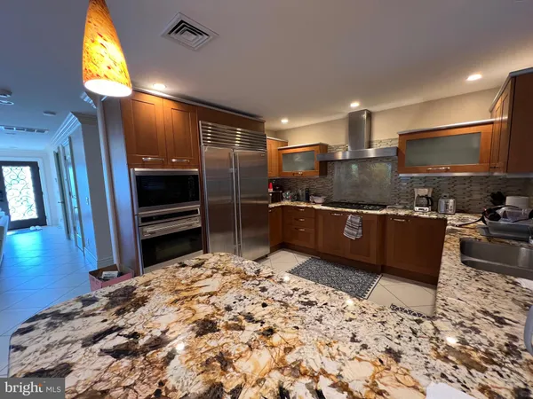 a kitchen with stainless steel appliances kitchen island granite countertop a sink stove and refrigerator