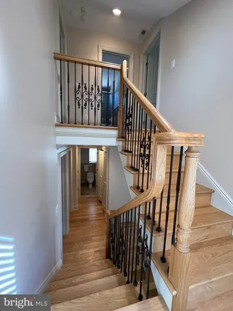 a view of staircase with lots of frames on wall and wooden floor
