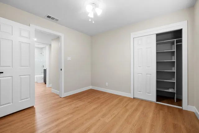 a view of empty room with wooden floor and closet