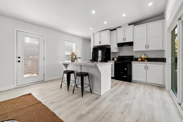 a large kitchen with kitchen island a cabinets wooden floor and a dining table