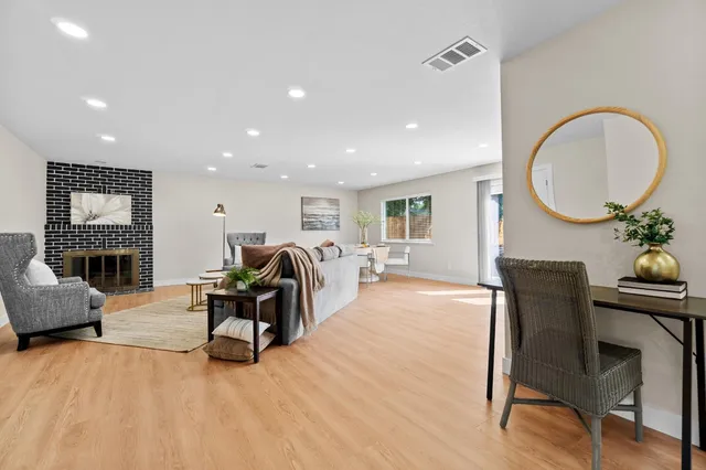 a living room with furniture a fireplace and a potted plant