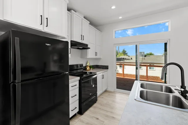 a kitchen with granite countertop a refrigerator and a sink