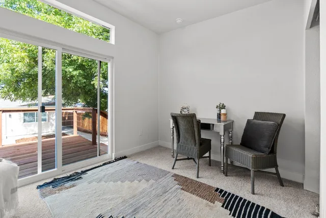 a dining room with furniture and a floor to ceiling window