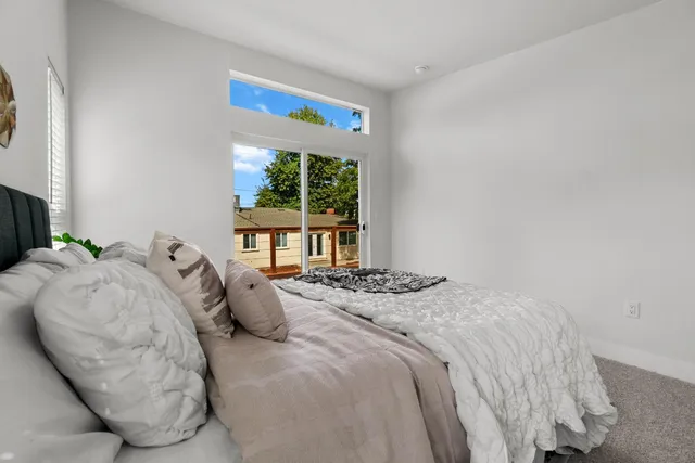 a bedroom with bed and a large window